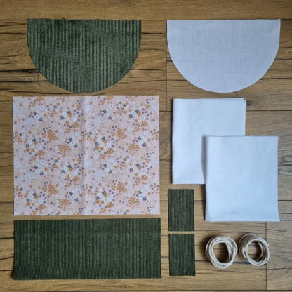 Kit prêt-à-coudre sac à dos pochon en velours vert avec tissu à motif floral à dominante rose : pièces en tissu, doublure blanche et cordons inclus, rabat demi-lune assorti.