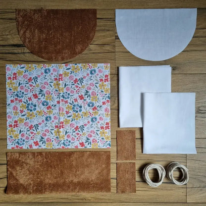 Kit prêt-à-coudre pour sac à dos pochon avec rabat demi-lune, tissu fleuri motif Bridget et velours côtelé marron, pièces prédécoupées et cordelettes incluses.