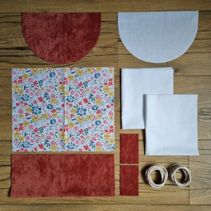 Kit couture pour débutant pour réaliser un sac à dos pochon avec rabat demi-lune en velours terracotta et tissu motif fleuri multicolore, pièces prédécoupées et cordons inclus.