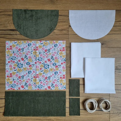 Kit prêt-à-coudre sac à dos pochon avec rabat en velours côtelé vert et tissu fleuri coloré motif Bridget, avec pièces prédécoupées et cordons en coton.