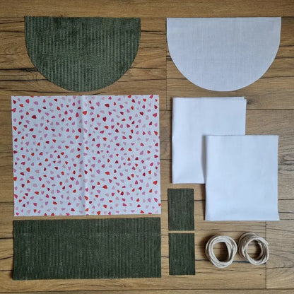 Kit prêt-à-coudre sac à dos pochon en velours vert avec rabat demi-lune et tissu imprimé cœurs roses et rouges, idéal pour un projet couture DIY. Tutoriel vidéo pas à pas inclus.