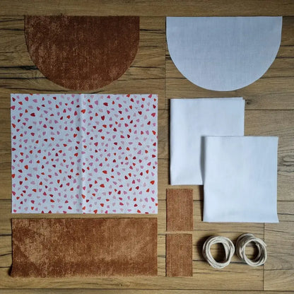 Kit couture pour débutant pour réaliser un sac à dos pochon en velours marron avec tissu imprimé de petits cœurs rouges et roses sur fond blanc, idéal pour une création couture pleine de tendresse. Tissus prédécoupés et cordelette fournie.