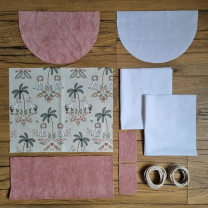 Kit prêt-à-coudre sac à dos pochon en velours rose avec tissu jungle imprimé lions et zèbres, parfait pour un projet couture enfant coloré et exotique. Kit couture pour débutant avec tutoriel vidéo inclus.