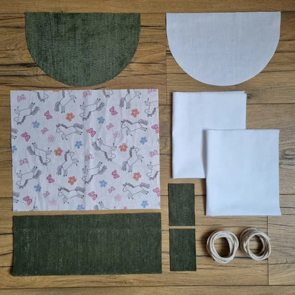 Kit couture débutant pour réaliser un sac à dos pochon personnalisé en velours vert avec tissu licorne. Ce kit prêt-à-coudre comprend les tissus prédécoupés, la cordelette, et est fourni avec un tutoriel vidéo pas à pas.