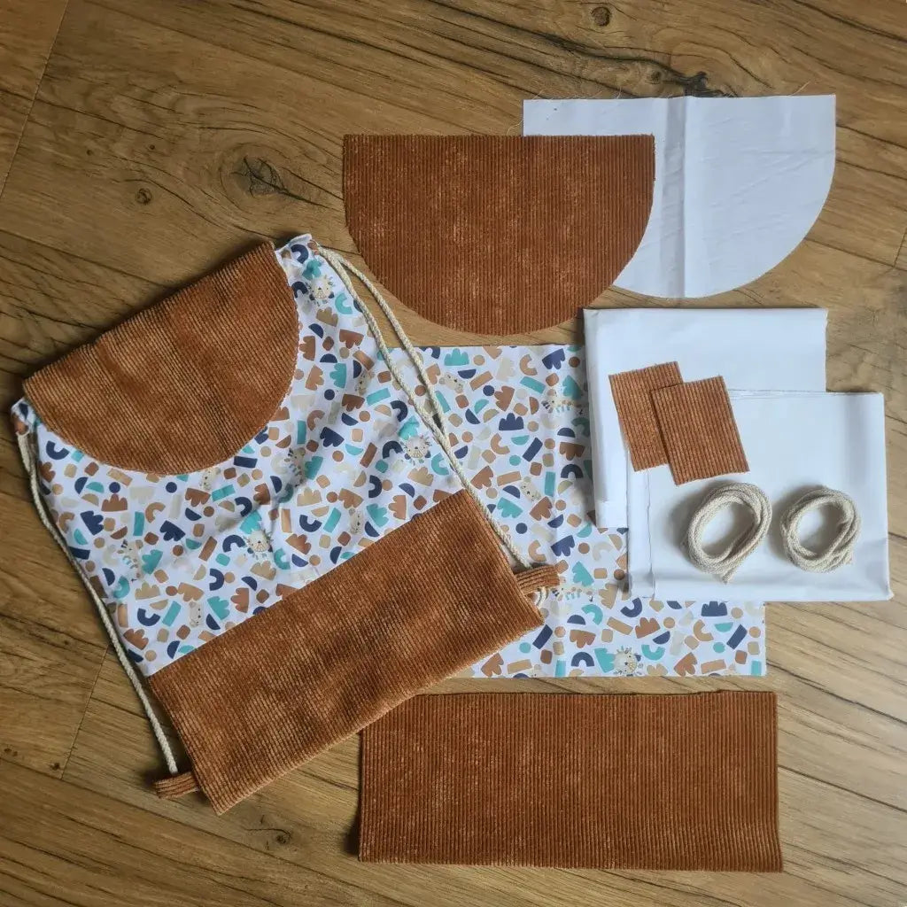 A droite, les différents éléments composant le kit "prêt à coudre" pour un sac à dos enfant au format pochon avec rabat (motif du tissu Ptiwi et base et rabat en velours côtelé marron). A gauche, le produit déjà cousu pour voir le rendu final.