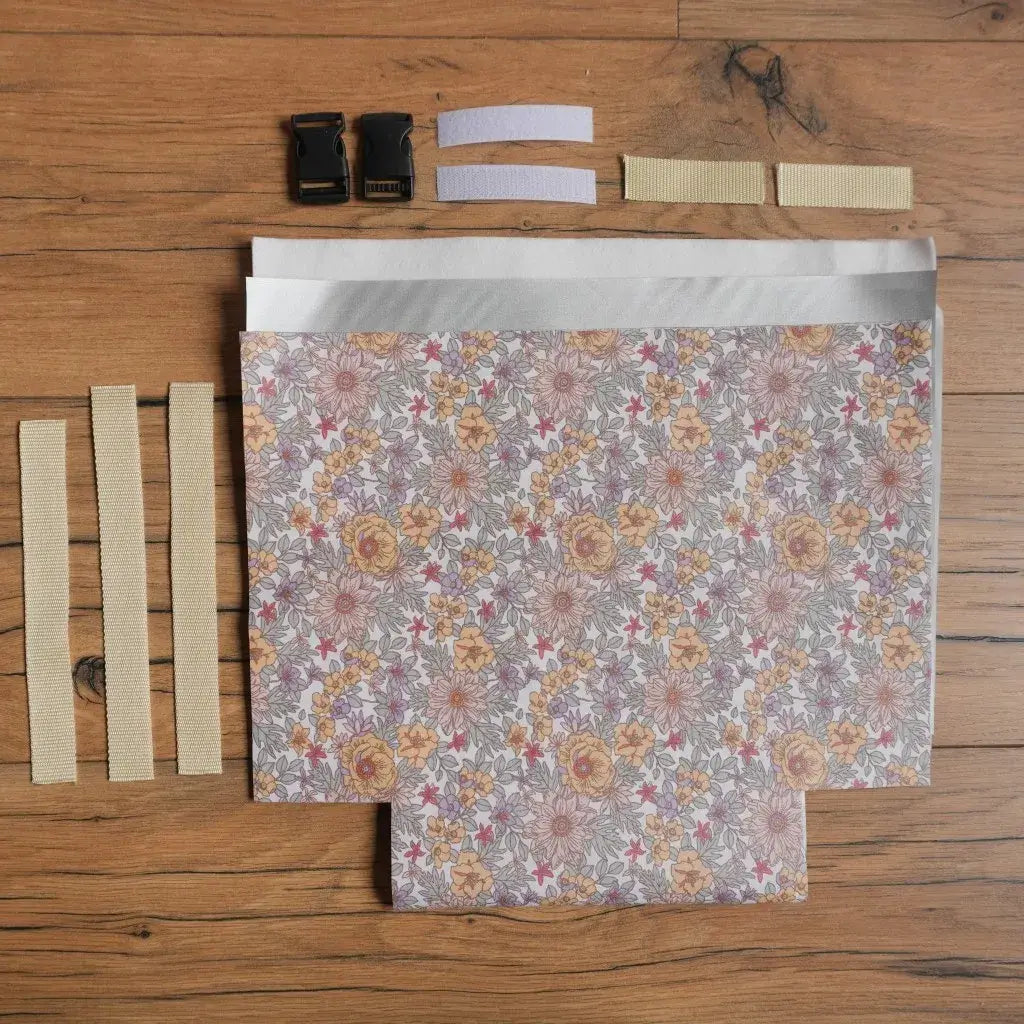 Kit prêt-à-coudre pour réaliser un sac repas isotherme en coton enduit à motif fleuri mauve et jaune, comprenant tissu découpé, sangles, attaches, bandes scratch et doublure. Ensemble complet idéal pour les passionnés de couture souhaitant confectionner un lunch bag écologique, réutilisable et pratique pour emporter ses repas au travail, à l’école ou en pique-nique.