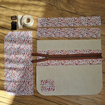 Kit couture complet pour réaliser un tablier ceinture élégant en velours côtelé beige, rehaussé d’un tissu fleuri. Contient les pièces découpées, une fermeture éclair, une sangle en coton, une boucle clip et des éléments assortis pour une finition soignée.