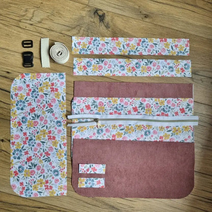 Kit prêt-à-coudre pour tablier ceinture personnalisable, en velours côtelé rose et tissu fleuri multicolore. Comprend toutes les pièces de tissu prédécoupées, une fermeture éclair, une sangle réglable et des boucles en plastique. Idéal pour la couture DIY et les activités créatives artisanales.
