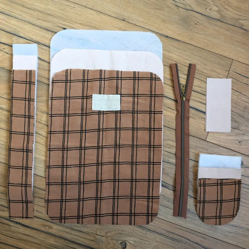Ensemble prêt-à-coudre complet pour réaliser une trousse de toilette artisanale en tissu à carreaux vintage. Le kit inclut une fermeture éclair assortie, des pièces de tissu prédécoupées et une étiquette personnalisable. Un projet couture facile et créatif pour fabriquer une trousse de toilette unique et pratique, idéale pour ranger maquillage et accessoires.