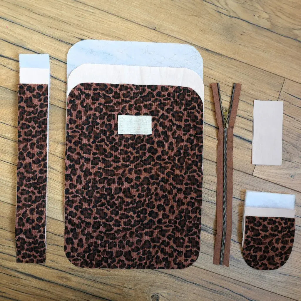 Ensemble prêt-à-coudre complet pour trousse de toilette zippée au motif léopard. Avec fermeture éclair, étiquette personnalisable et éléments de tissu coupés à la forme, ce kit couture tendance offre un projet créatif simple et rapide pour réaliser une trousse élégante et résistante, parfaite pour organiser cosmétiques et essentiels du quotidien.
