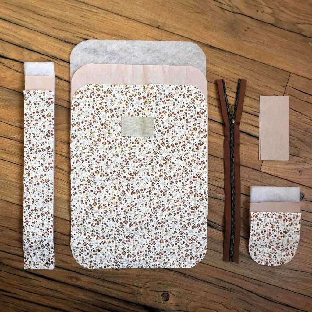 Kit prêt-à-coudre pour trousse de toilette en tissu crème à petites fleurs champêtres, comprenant pièces de tissu prédécoupées, fermeture éclair marron et patch personnalisable. Idéal pour les passionnés de DIY, ce kit couture permet de réaliser une trousse zippée artisanale et tendance, parfaite pour organiser maquillage, cosmétiques ou accessoires de voyage.