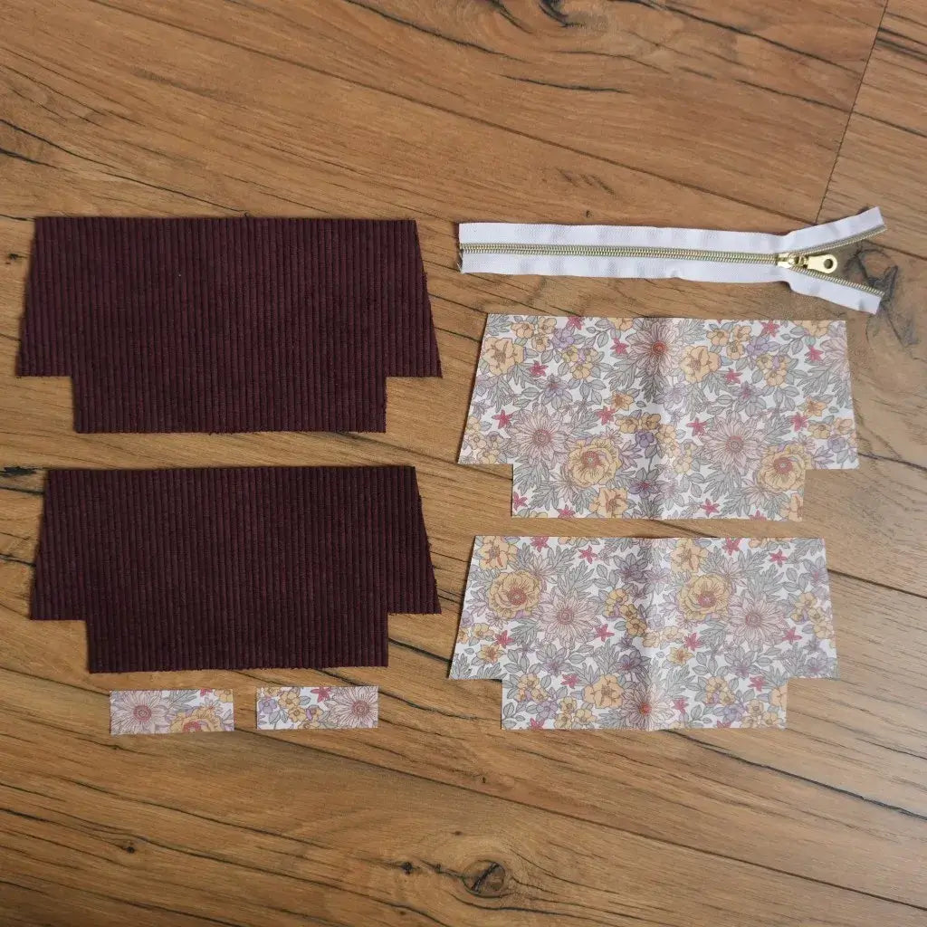 Kit prêt-à-coudre pour trousse d’école en velours côtelé prune et coton fleuri, comprenant pièces de tissu prédécoupées et fermeture éclair dorée. Ensemble idéal pour un projet couture DIY facile, permettant de fabriquer une trousse personnalisée pratique pour crayons, accessoires ou maquillage.