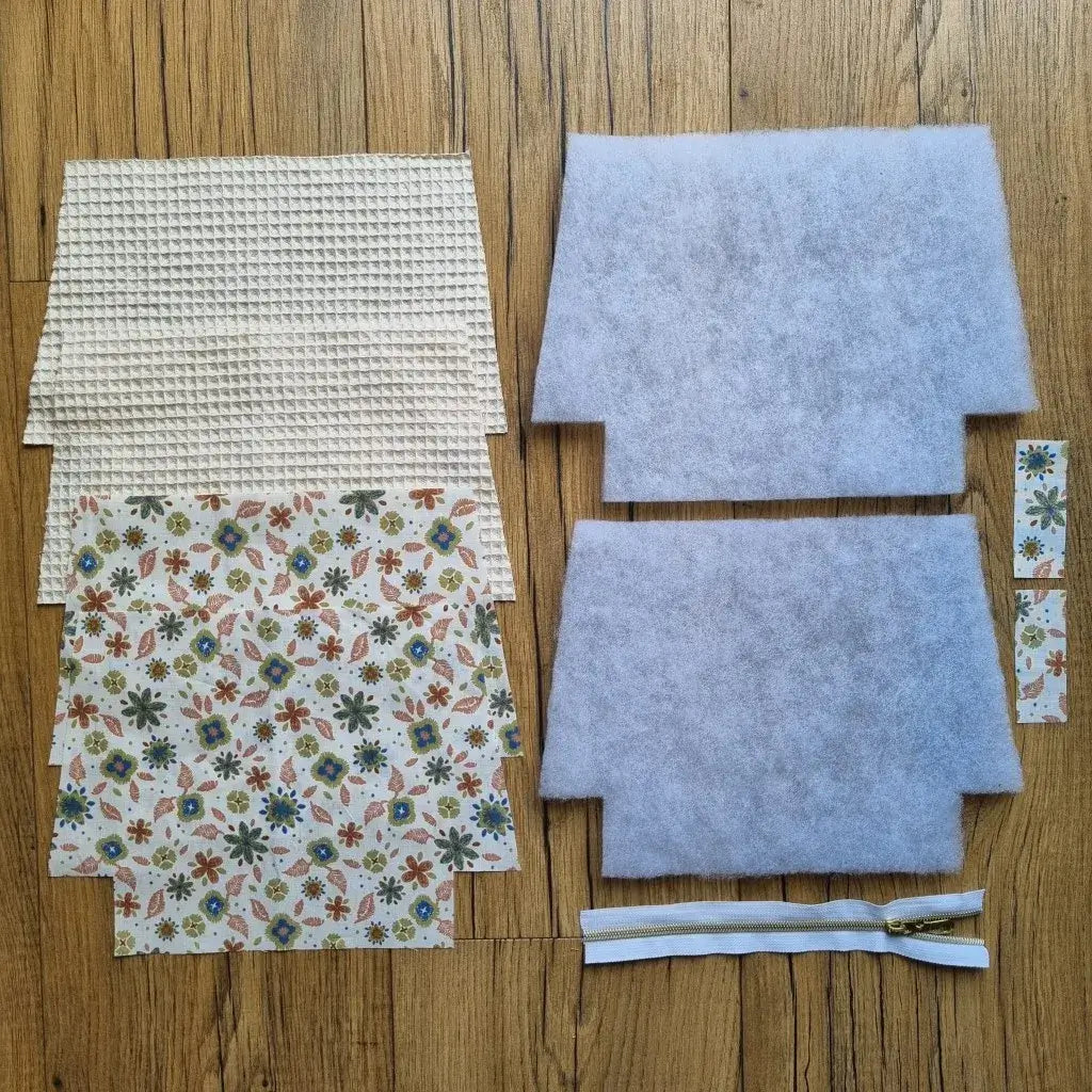 Kit prêt-à-coudre pour trousse zippée en tissu nid d’abeille naturel et coton imprimé fleuri. Contient toutes les pièces prédécoupées : doublure, molleton, fermeture éclair blanche. Idéal projet couture facile, débutant ou atelier DIY.