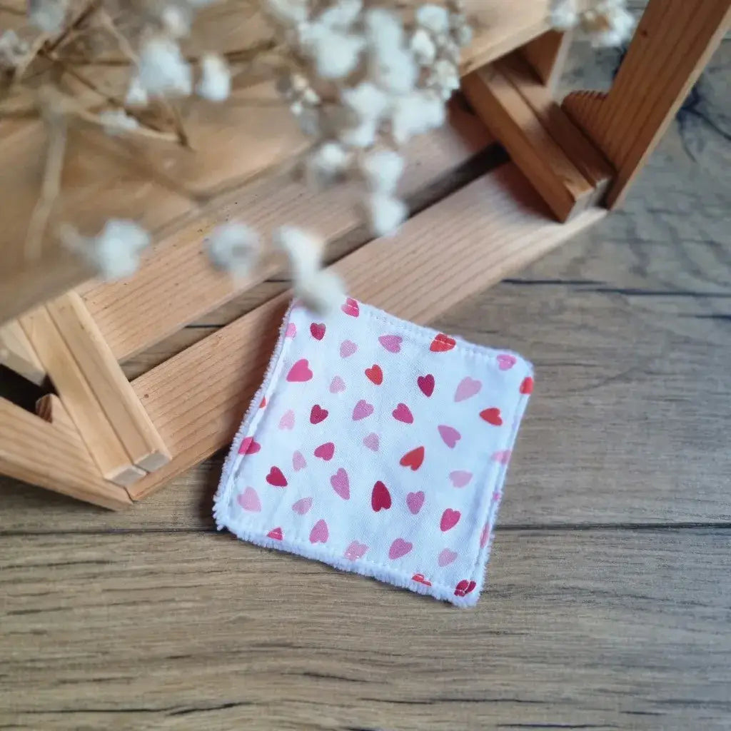 Lingette démaquillante lavable en coton blanc à motifs de petits cœurs rouges et roses, face éponge bambou.
