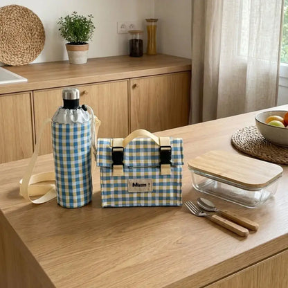 lunch bag isotherme carreaux bleus avec porte gourde assorti et boîte repas sur table bois