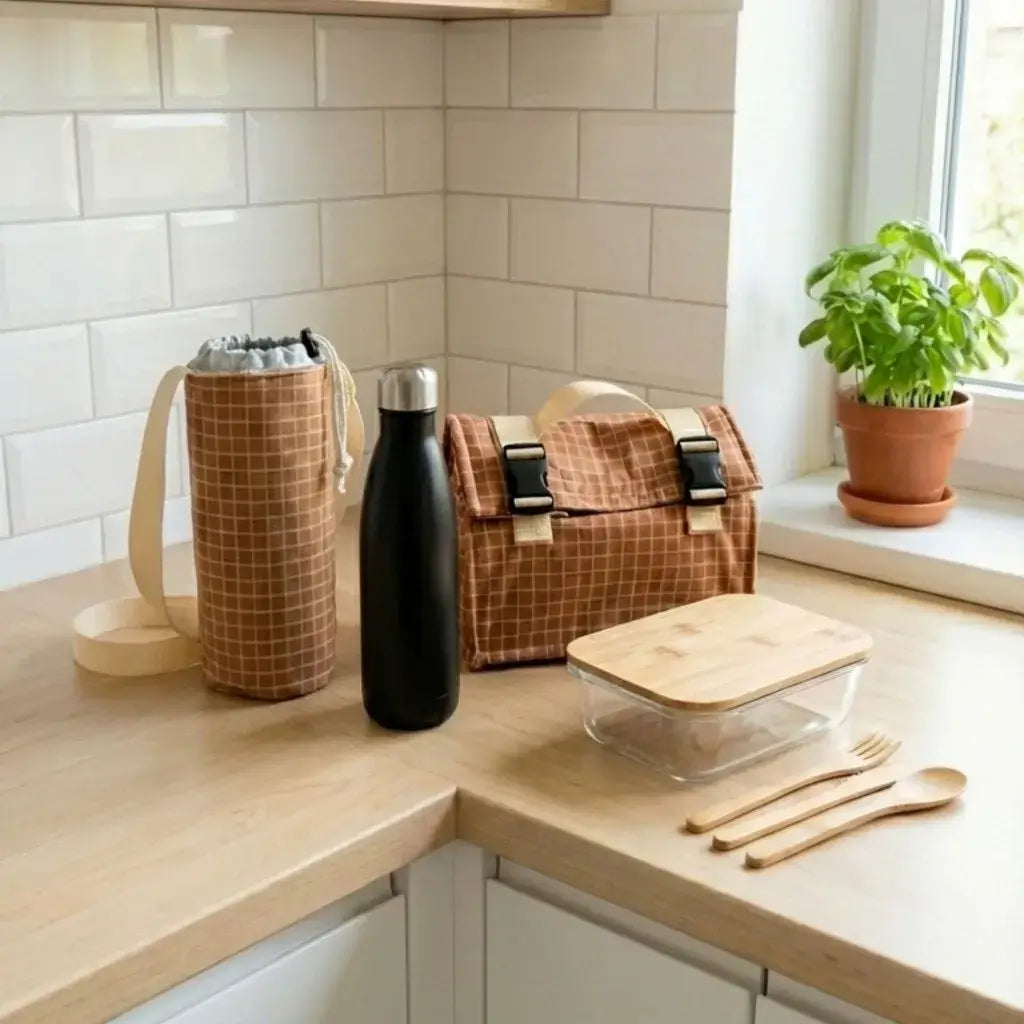 lunch bag isotherme motif carreaux marron avec porte gourde et boîte repas sur plan cuisine