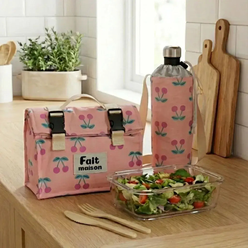 lunch bag isotherme rose motif cerises avec porte gourde et boîte repas salade sur plan bois