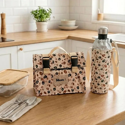 lunch bag isotherme motif léopard avec porte gourde assorti et boîte repas sur plan cuisine
