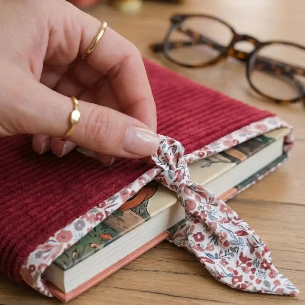 Pochette à livre velours lie de vin fermée par un ruban Liberty, protection élégante pour roman.