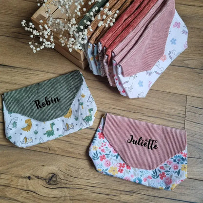 Pochettes imperméables et réutilisables personnalisées avec prénom – modèles en tissu à motifs ludiques ou fleuris et rabats en velours côtelé, idéales pour enfants ou adultes, à emporter à l’école, en sortie ou au quotidien.
