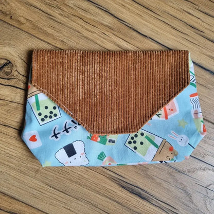 Pochette imperméable et réutilisable en tissu bleu motif kawaii gourmand et rabat en velours côtelé marron – un accessoire original, lavable et plein de fantaisie pour transporter goûter, mouchoirs ou petits trésors du quotidien.