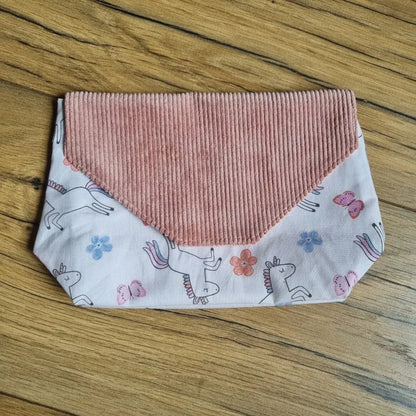 Pochette imperméable et réutilisable pour enfants, en velours côtelé rose poudré et tissu imprimé licornes – une solution ludique et pratique pour glisser mouchoirs, goûter ou petits trésors dans le cartable.