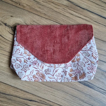 Trousse plate imperméable en tissu à inspiration orientale, ornée de motifs floraux cuivrés et d’un rabat en velours côtelé terracotta – un accessoire nomade, pratique et esthétique pour glisser petits objets, soins ou protections discrètement.
