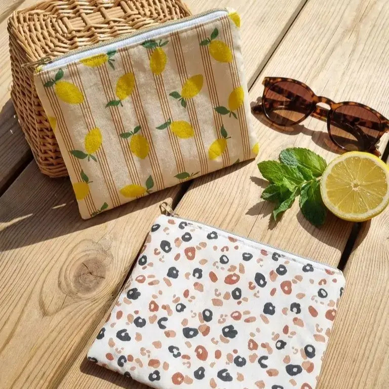 trousses plates en coton enduit motif citron et léopard avec fermeture zippée et format nomade