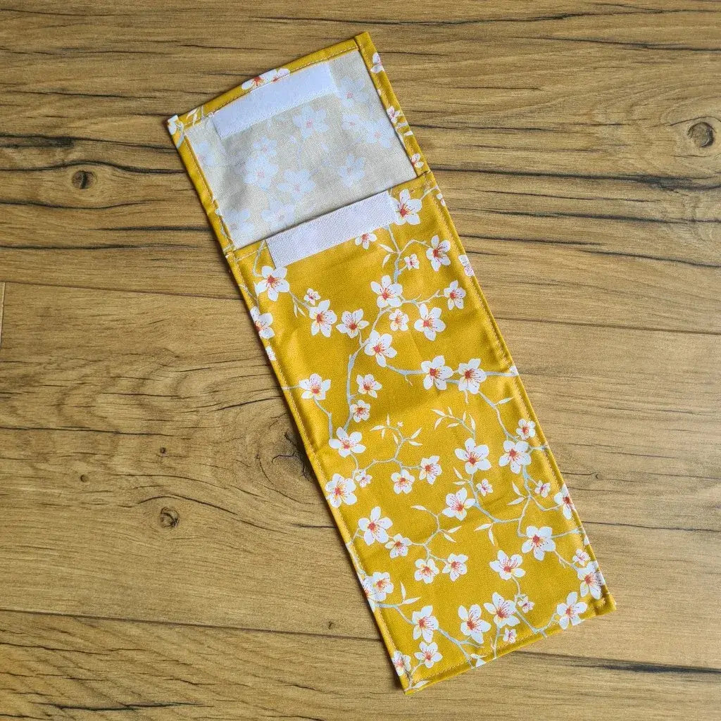 Pochette à sandwich lavable et réutilisable en coton enduit au motif fleurs jaunes et au format baguette.