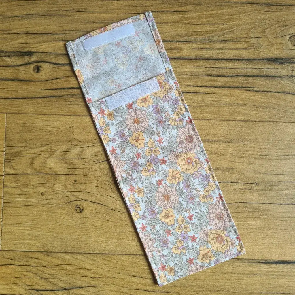 Pochette à sandwich lavable et réutilisable en coton enduit au motif fleurs mauves et au format baguette.