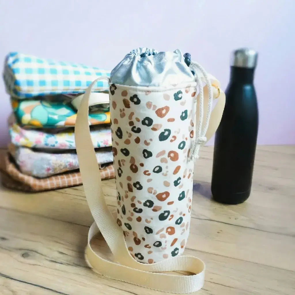 Porte-gourde isotherme motif léopard en coton enduit avec bandoulière beige et doublure thermique.