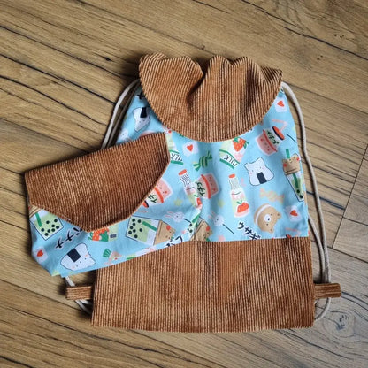 Ensemble assorti cousu main comprenant un sac à dos pochon et une pochette en velours côtelé marron et tissu bleu à motifs kawaii (nourriture japonaise, animaux mignons, bubble tea). Sac à cordons avec rabat, idéal pour enfant à la crèche ou à l’école. Pochette pratique pour petits accessoires.