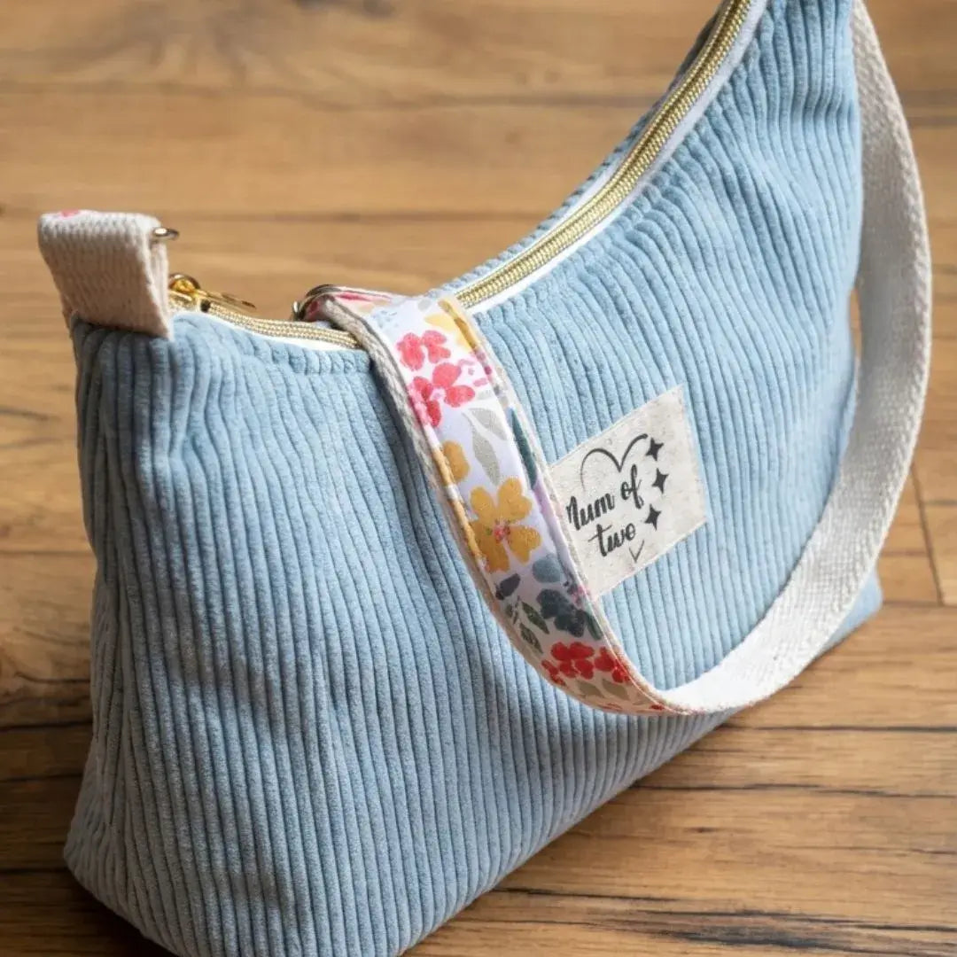 Petit sac bandoulière bleu ciel en velours côtelé avec sangle fleurie.