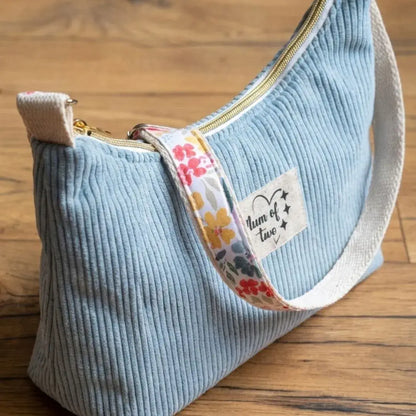 Petit sac bandoulière bleu ciel en velours côtelé avec sangle fleurie.