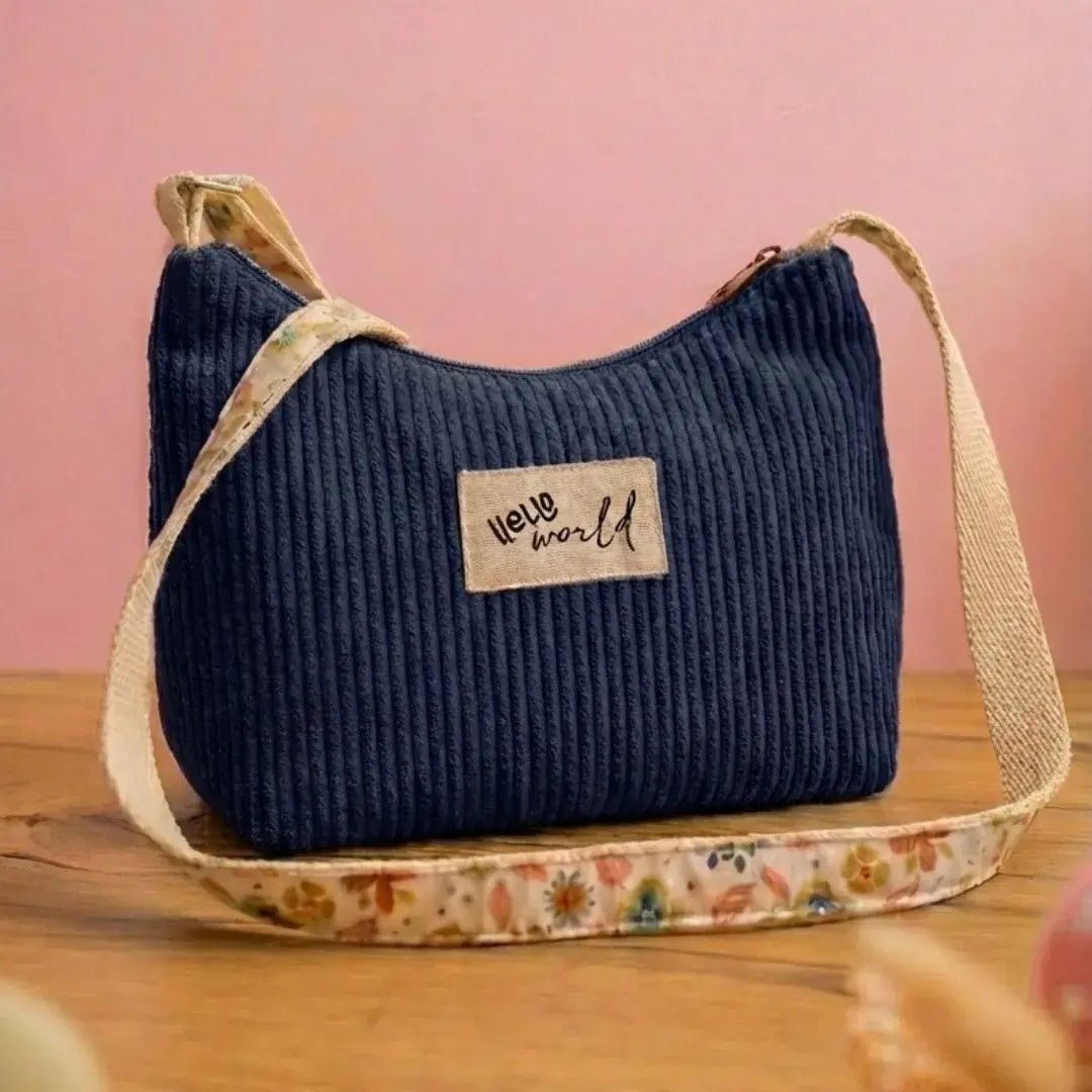 Sac bandoulière bleu marine en velours côtelé, étiquette "Hello World".