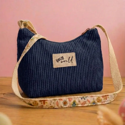 Sac bandoulière bleu marine en velours côtelé, étiquette "Hello World".
