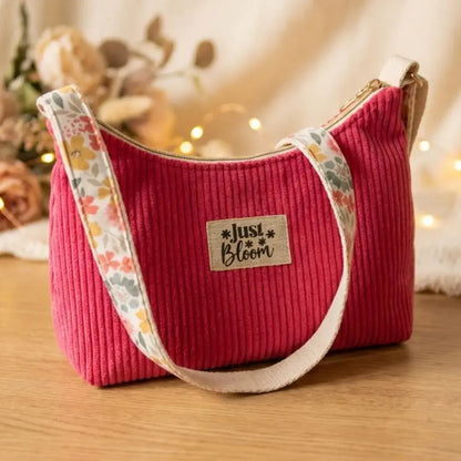 Sac bandoulière en velours côtelé rose framboise avec sangle fleurie style bohème.