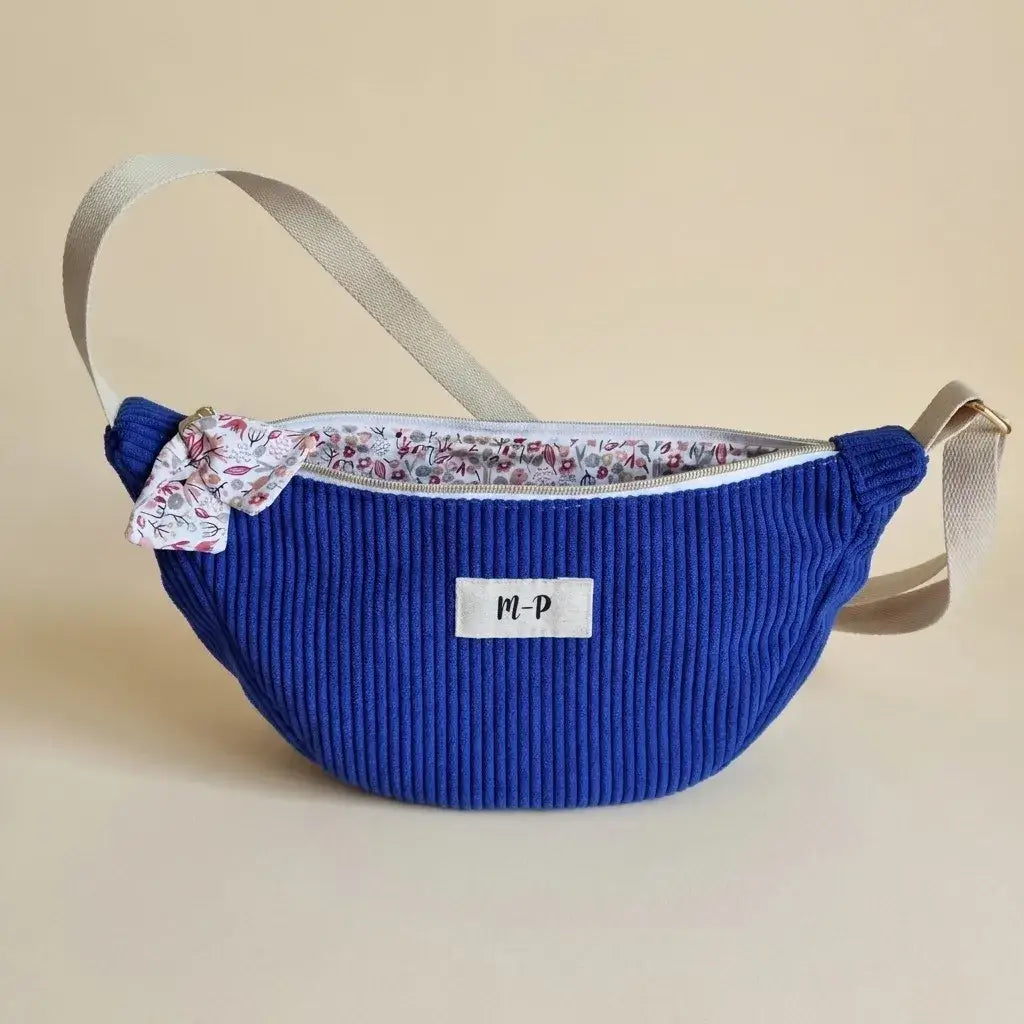 Sac banane demi-lune bleu roi en velours côtelé, doublure fleurie, sangle écrue et étiquette initiales
