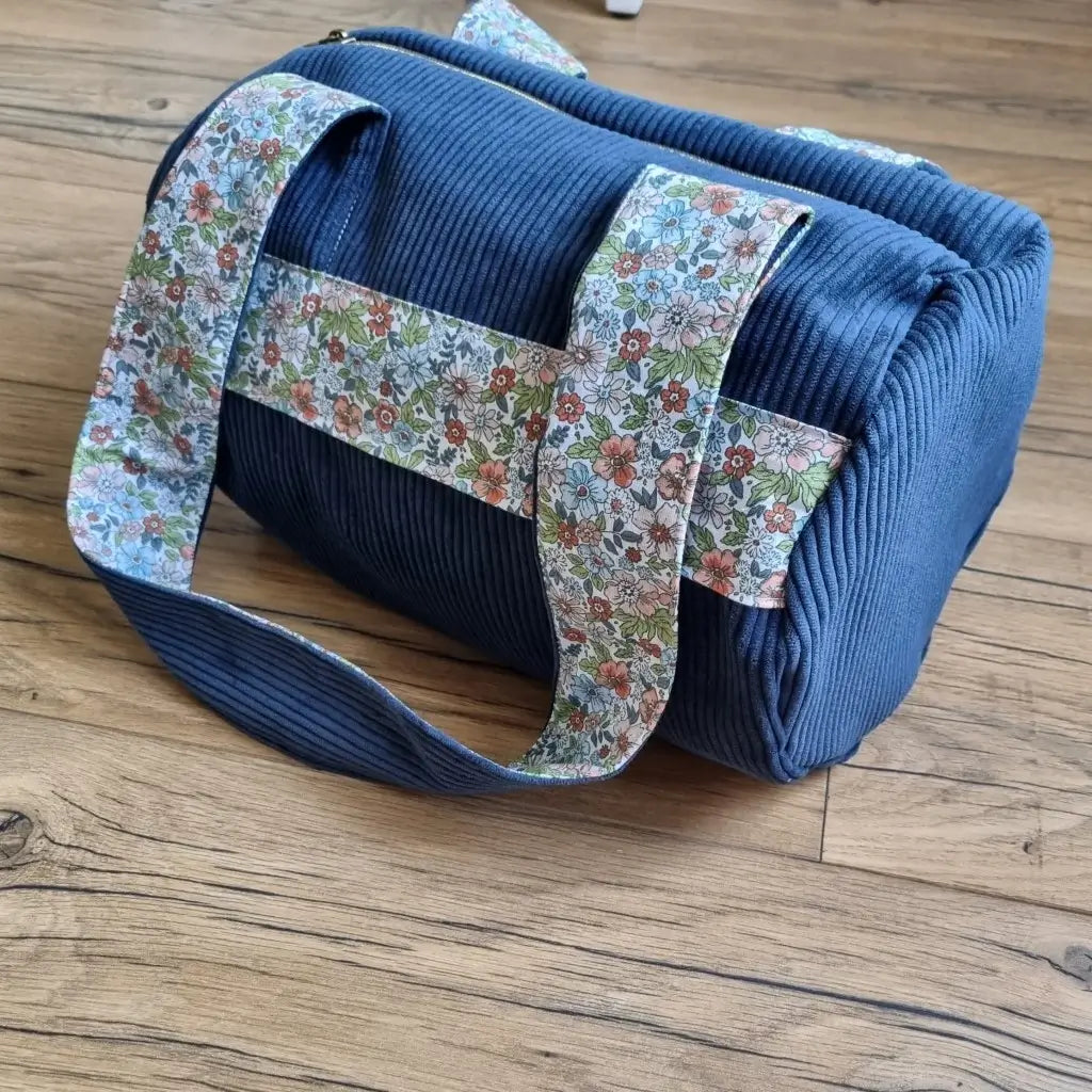 Sac polochon en velours côtelé bleu foncé avec une bande et l'intérieur des anses en tissu coton imprimé fleuri