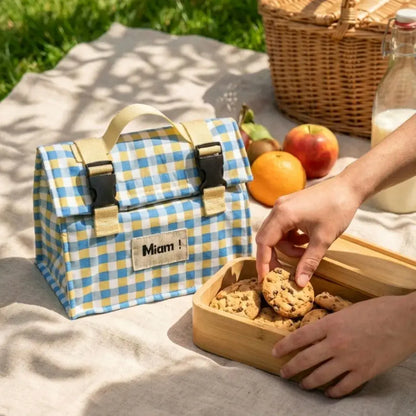 Sac repas isotherme à carreaux bleus et boîte à cookies en pique-nique.