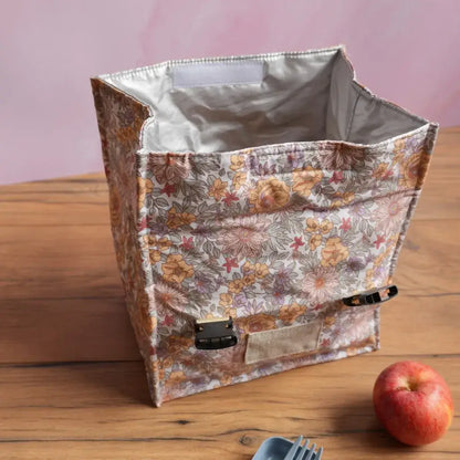 Sac repas isotherme en coton enduit motif fleuri, présenté ouvert pour montrer l’intérieur doublé isolant, idéal pour conserver plats, fruits ou boissons au frais. Lunch bag pratique et réutilisable, conçu pour emporter son déjeuner à l’école, au bureau ou en pique-nique avec élégance.