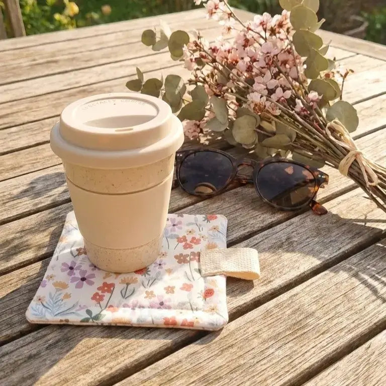 sous-verre molletonné en tissu fleuri avec gobelet réutilisable sur table extérieure