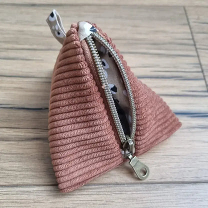 Trousse berlingot en tissu velours côtelé marron et intérieur léopard posée sur un parquet en chêne