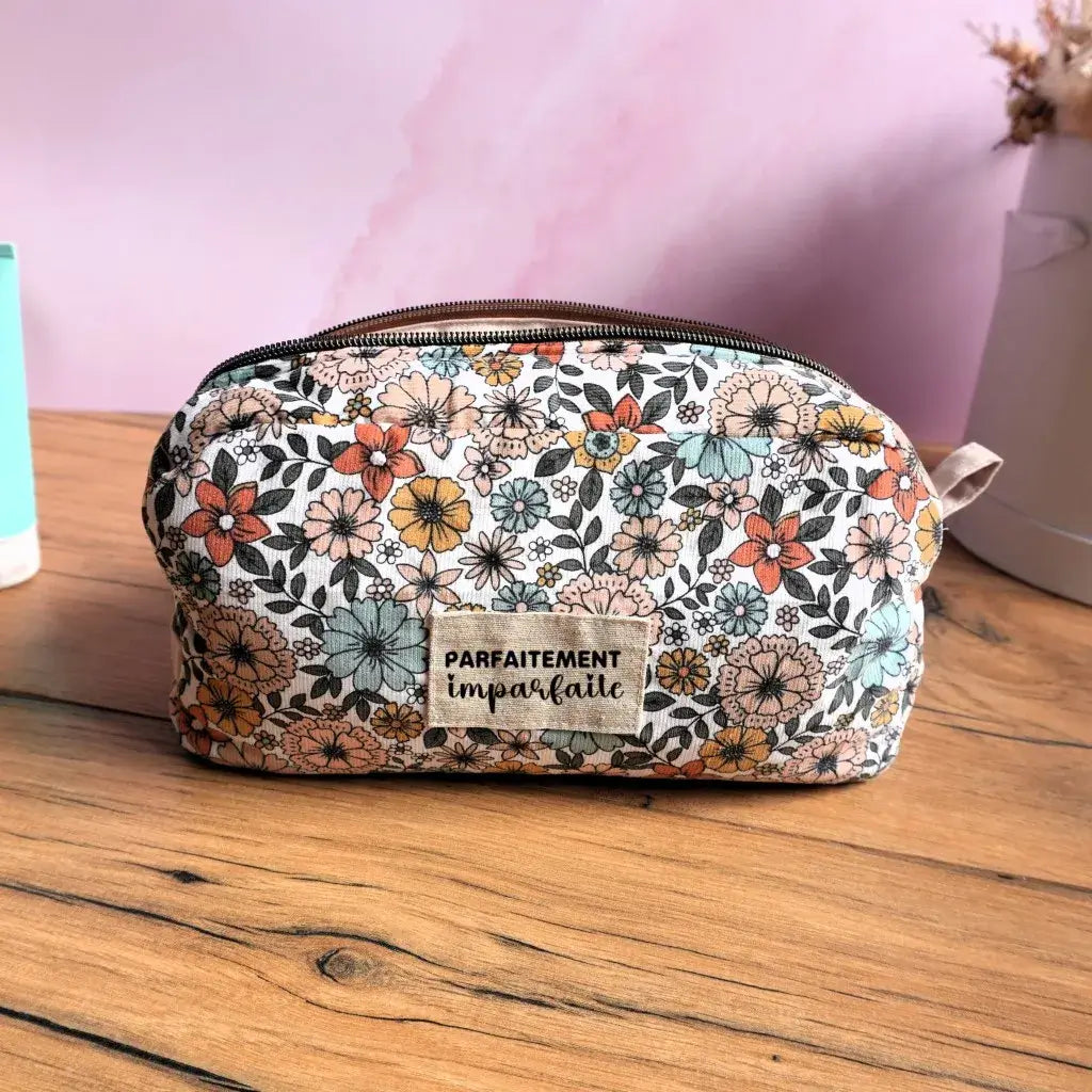 Trousse de toilette fleurie au style rétro, ornée d’une étiquette en tissu avec l’inscription « Parfaitement imparfaite ». Compacte et pratique, cette trousse zippée en tissu coloré est idéale comme trousse de maquillage, pochette de voyage ou rangement beauté. Son design original et tendance en fait un accessoire indispensable pour emporter cosmétiques et soins avec élégance.
