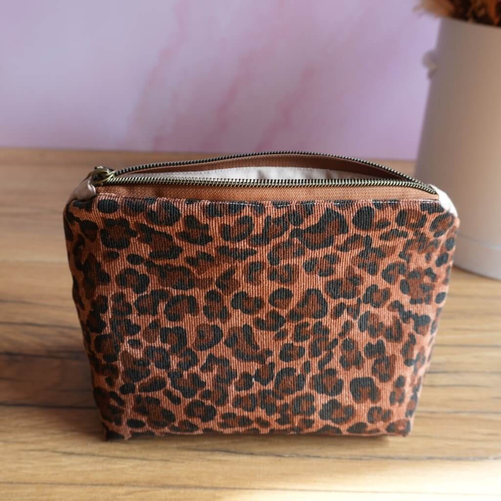 Trousse zippée à imprimé léopard noir. Pochette artisanale pratique et tendance, idéale pour organiser maquillage, accessoires de beauté, stylos ou petits objets dans un sac. Son motif animalier audacieux apporte une touche mode et originale, parfaite comme trousse de toilette, de voyage ou de rangement du quotidien.