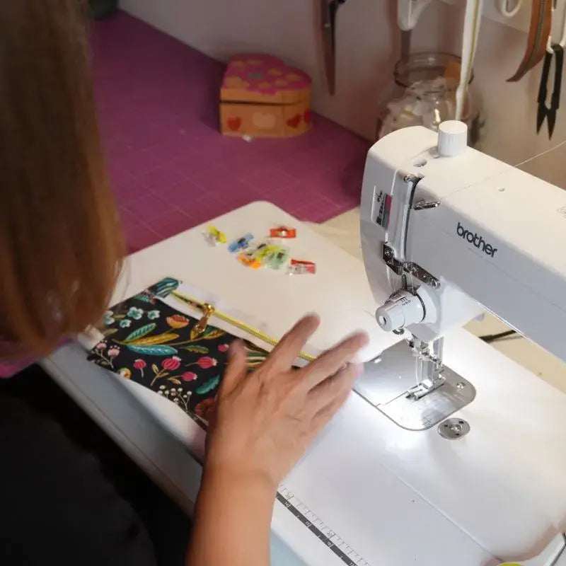 Couture d'une pochette en tissu fleuri sur machine à coudre dans l'atelier Chtipops.