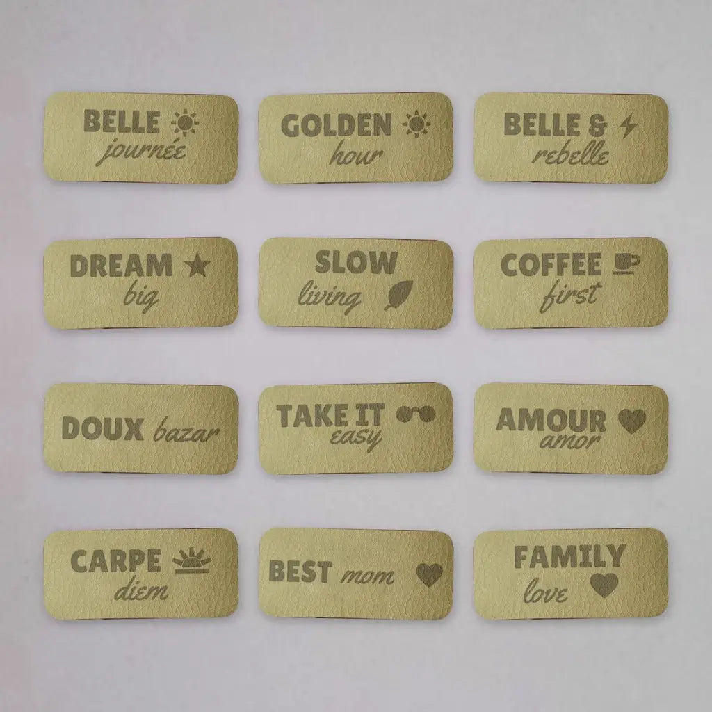 Douze étiquettes à coudre en simili cuir gravées de messages, disposées en grille