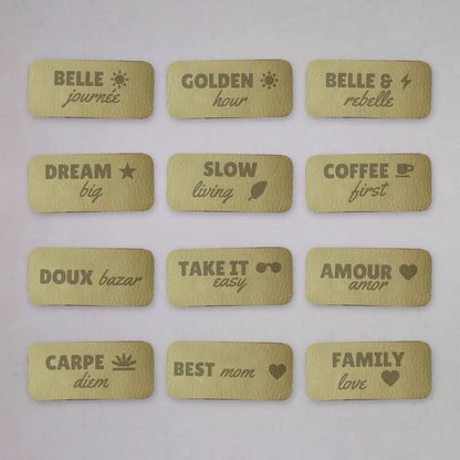 Douze étiquettes à coudre en simili cuir gravées de messages, disposées en grille