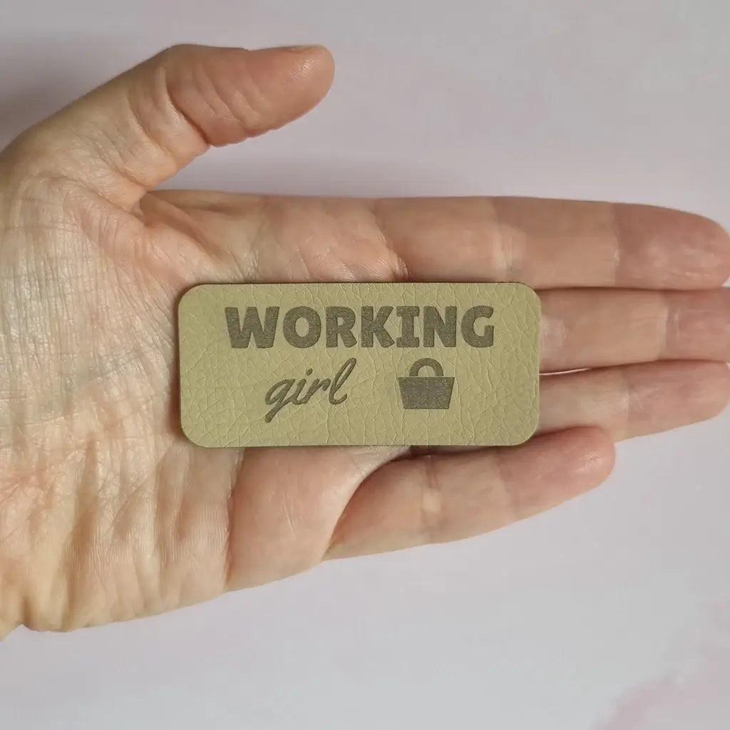 Étiquette simili cuir gravée Working girl avec petit sac à main, vue dans la main