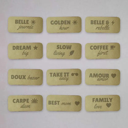 Douze étiquettes simili cuir beige gravées de messages comme Slow living, Dream big et Carpe diem